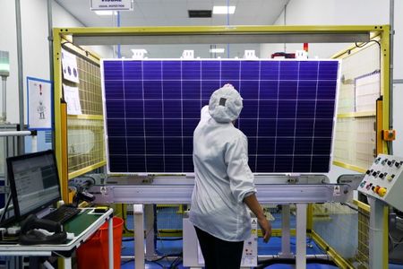 Funcionária checa qualidade de módulo solar em fábrica de Campinas, SP