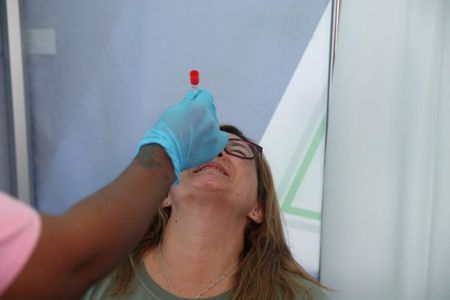 Mulher passa por teste de Covid-19 em aeroporto O.R. Tambo, em Johanesburgo, antes de voo para Londres