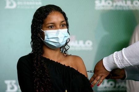 Jovem recebe vacina contra Covid-19 em São Paulo