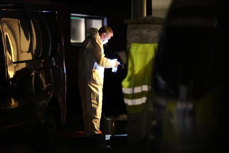 Perito forense coleta evidências na parte de fora da casa de uma família após polícia encontrar dois adultos e três crianças mortos em Berlim, na Alemanha