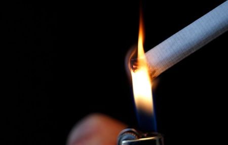 Mulher acende cigarro em Paris