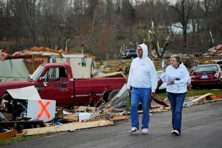 Casal caminha em meio a destroços em Earlington, Kentucky, após passagem de tufão Casal caminha em meio a destroços em Earlington, Kentucky, após passagem de tufão