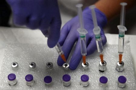 Agente de saúde usa solução salina para preparar doses da vacina “Comirnaty” da Pfizer-BioNTech contra a Covid-19 em centro de vacinação em Madri, Espanha