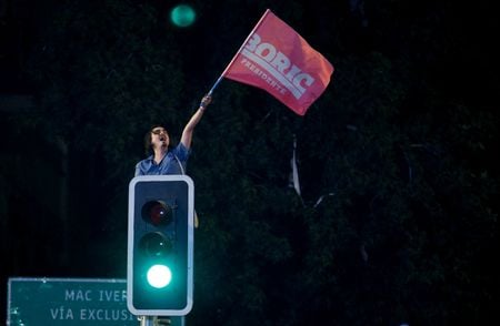 Apoiador do presidente eleito do Chile, Gabriel Boric, comemora vitória com bandeira em semáforo de Santiago