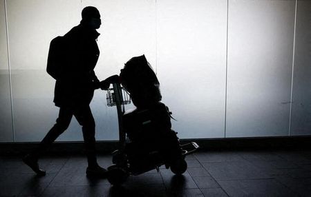Homem transporta bagagem em aeroporto da Itália