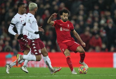 Mohamed Salah em ação acompanhado por Ezri Konsa e Douglas Luiz em jogo do Liverpool contra o Aston Villa