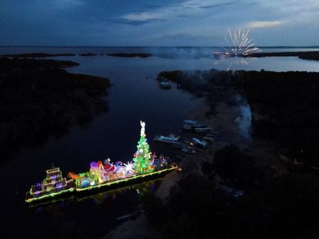 Embarcação natalina com árvore de Natal e Papai Noel gigante visita comunidade ribeirinha em Manaus