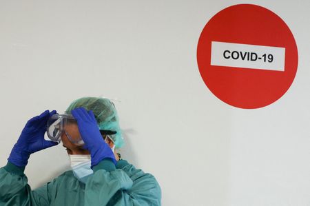 Profissional de saúde ajusta óculos de proteção durante pandemia de Covid-19 em hosputal de Barcelona