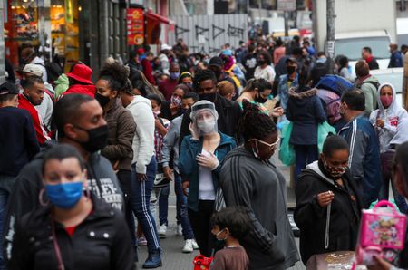 Pessoas caminham em rua de São Paulo durante pandemia de Covid-19