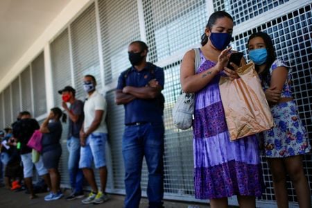 Pessoas fazem fila em agência da Caixa para receber o auxílio emergencial, em Ceilândia-DF