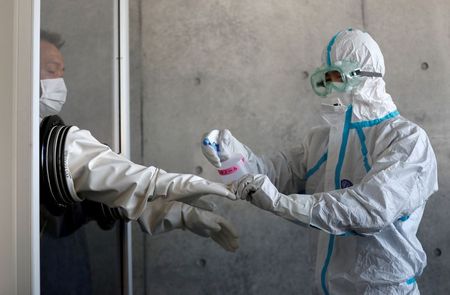 Profissional de saúde desinfecta luvas de colega em Tosuka, ao sul de Tóquio Profissional de saúde desinfecta luvas de colega em Tosuka, ao sul de Tóquio