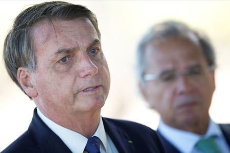 O ministro da Economia, Paulo Guedes, observa o presidente da República, Jair Bolsonaro. 27/04/2020. REUTERS/Ueslei Marcelino. O ministro da Economia, Paulo Guedes, observa o presidente da República, Jair Bolsonaro. 27/04/2020. REUTERS/Ueslei Marcelino.