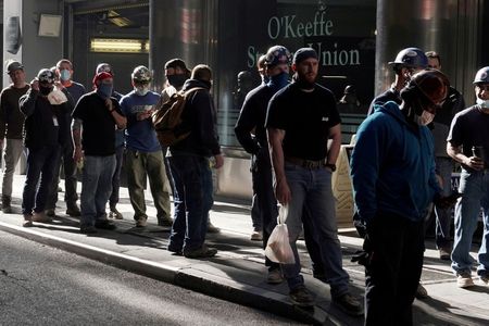 Trabalhadores de construção esperam para tirar temperatura ao voltarem ao trabalho após almoço em Nova York Trabalhadores de construção esperam para tirar temperatura ao voltarem ao trabalho após almoço em Nova York