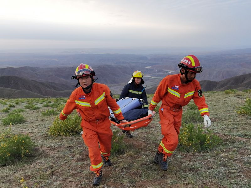 Equipes de resgate levam maca durante operação em local onde corredores de ultramaratona morreram de hipotermia, na China