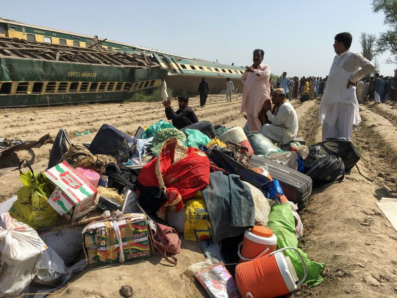Bagagem de passageiros perto de local de colisão entre trem e vagões descarrilados no Paquistão