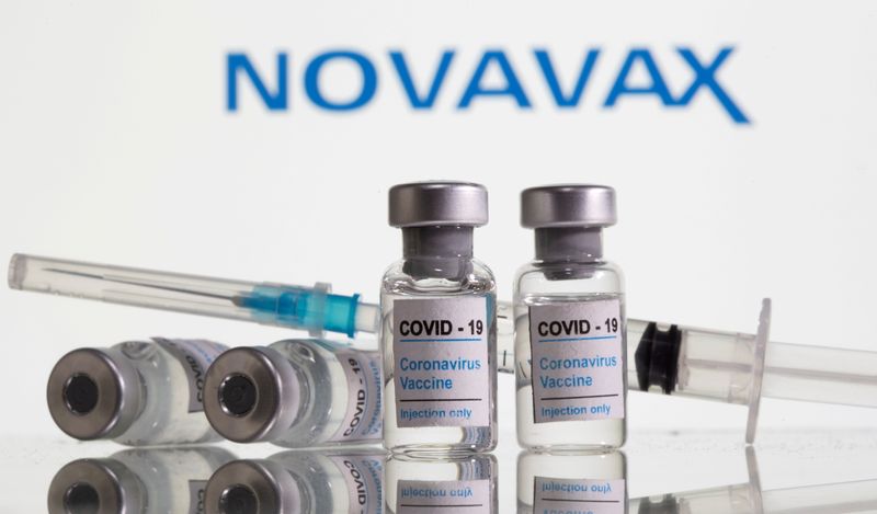 Frascos rotulados como de vacina contra Covid-19 com logo da Novavax ao fundo em foto de ilustração