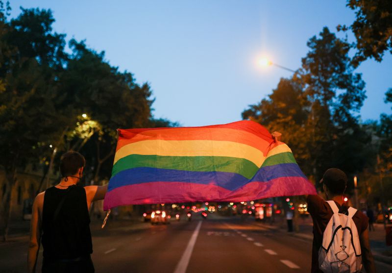 Ativistas seguram bandeira do arco-íris em protesto pela morte de Samuel Luiz, em Barcelona