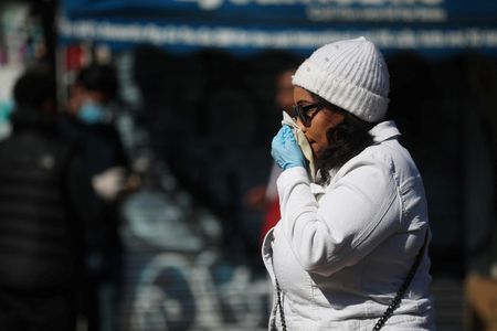 Mulher assoa o nariz no bairro de Dalston, em Londres, em meio à disseminação da Covid-19 no Reino Unido Mulher assoa o nariz no bairro de Dalston, em Londres, em meio à disseminação da Covid-19 no Reino Unido