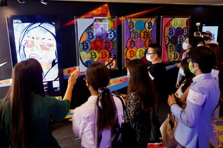 Visitantes caminham em frente a uma obra de arte convertida em NFT e leiloada online na Sotheby’s, em Hong Kong