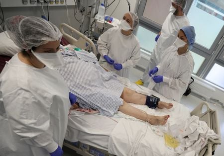 Profissionais de saúde tratam paciente com Covid-19 em unidade de terapia intensiva de hospital em Mulhouse, na França