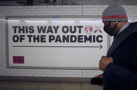 Homem passa em frente a anúncio sobre pandemia de Covid-19 em Londres