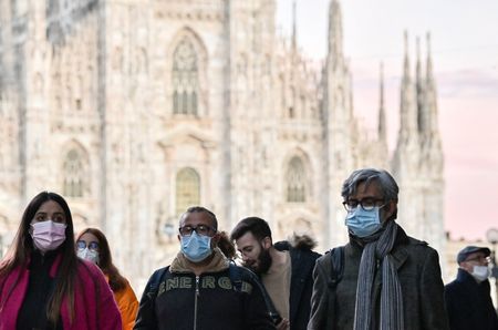 Pessoas usando máscaras caminham em Milão durante pandemia de Covid-19