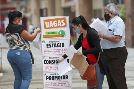 Mulher coloca currículo em caixa no centro de São Paulo