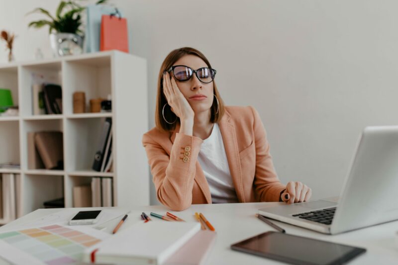 tired-worker-wearing-glasses-falling-asleep-workplace-snapportrait-lady-jacket-white-office-min-scaled-e1647536089536