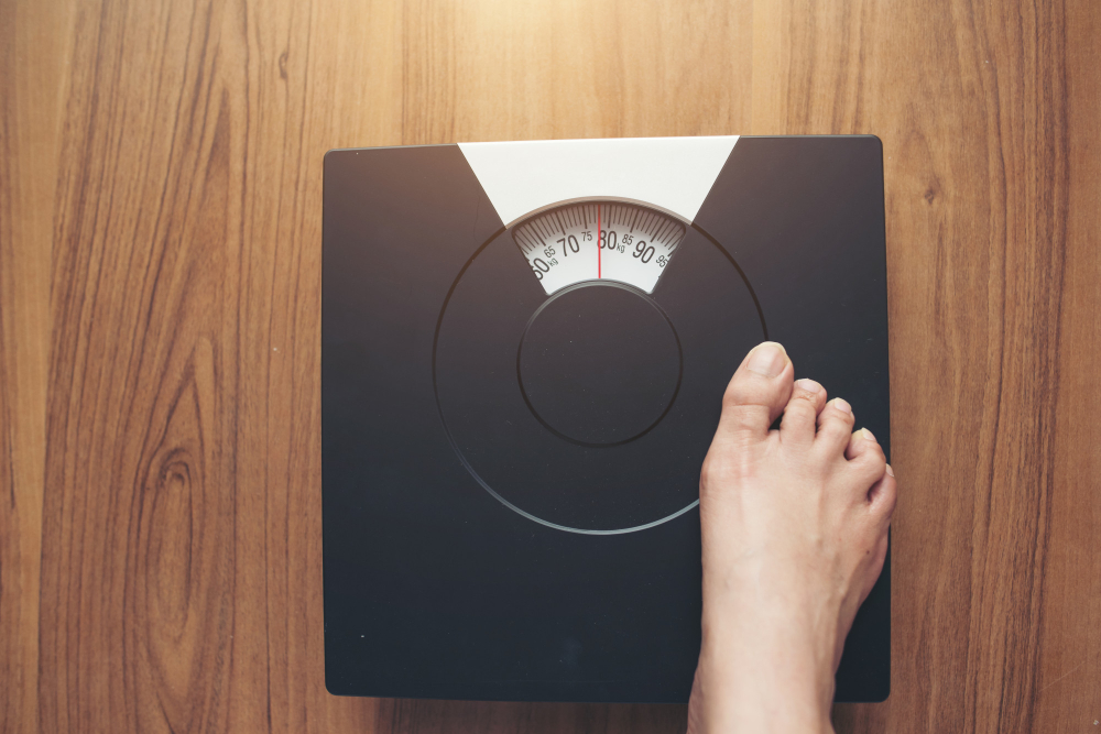 woman-feet-standing-on-weight-scale-on-wooden-background-1 woman-feet-standing-on-weight-scale-on-wooden-background-1