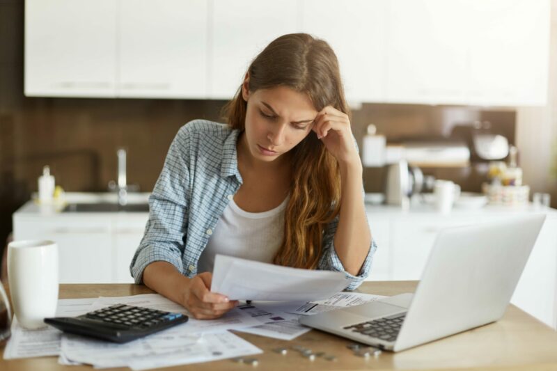 young-woman-checking-her-budget-doing-taxes-min-scaled-e1648579931166