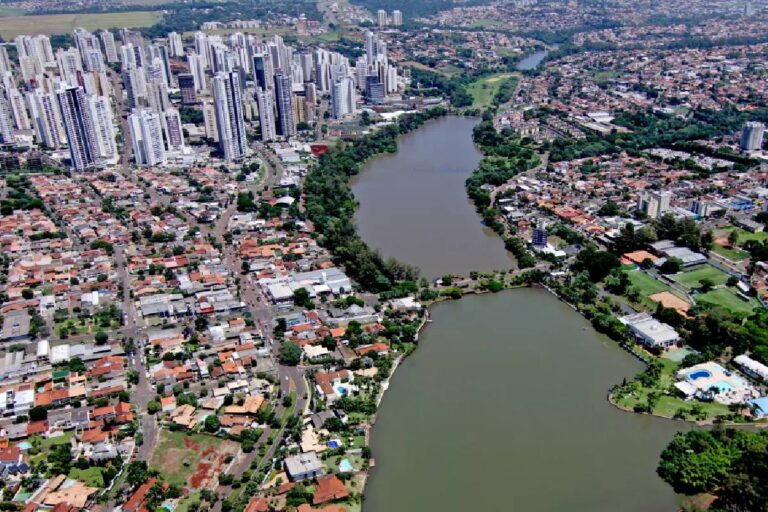 Imagem aérea de Londrina destacando o Lago Igapó e o mercado imobiliário na cidade.