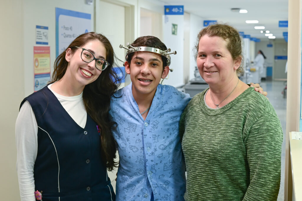 Higor ao lado da mãe e de uma enfermeira no Hospital Pequeno Príncipe, em Curitiba.