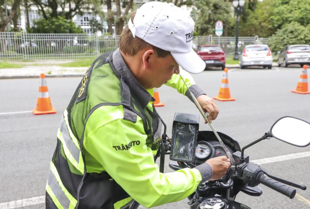 Guarda de trânsito instala antena corta-pipa em motocicleta.