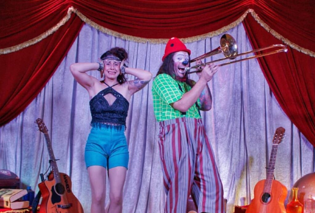 Foto de duas pessoas em cima de um palco em um espetáculo circense