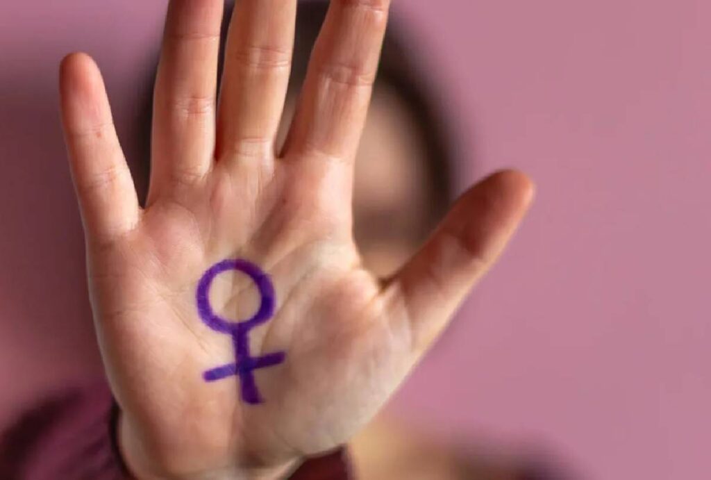 Mão feminina com gesto de 'pare' em alusão ao fim da violência doméstica
