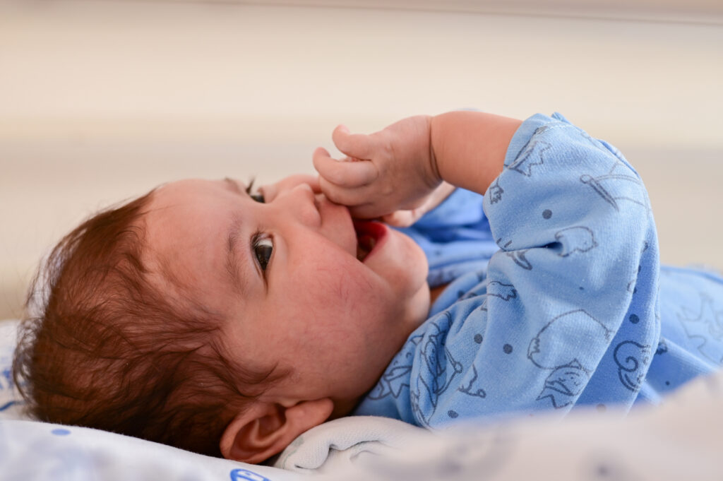 Arcangel deitado na cama sorrindo no Hospital Pequeno Príncipe, em Curitiba.