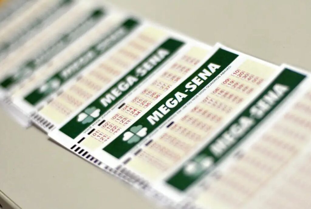 Seis bilhetes da Mega-Sena enfileirados em uma mesa
