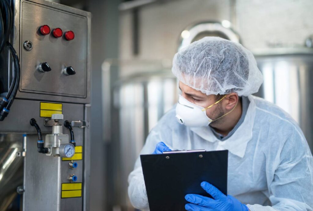 Técnico em Química trabalhando em indústria vistoriando máquina
