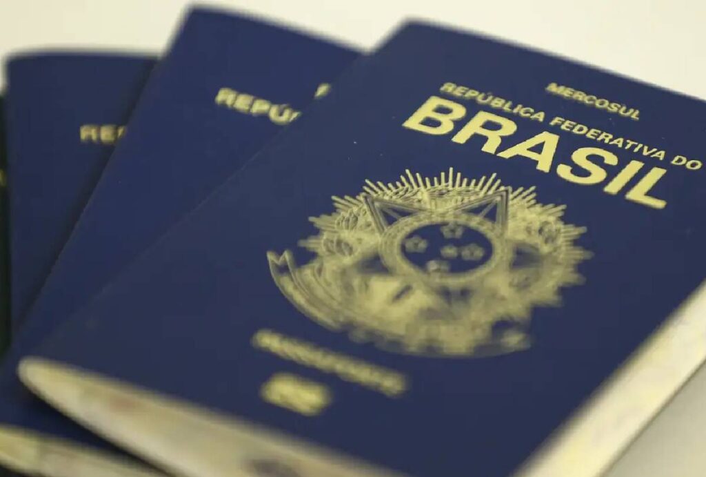 Passaportes brasileiros sobrepostos sobre mesa branca