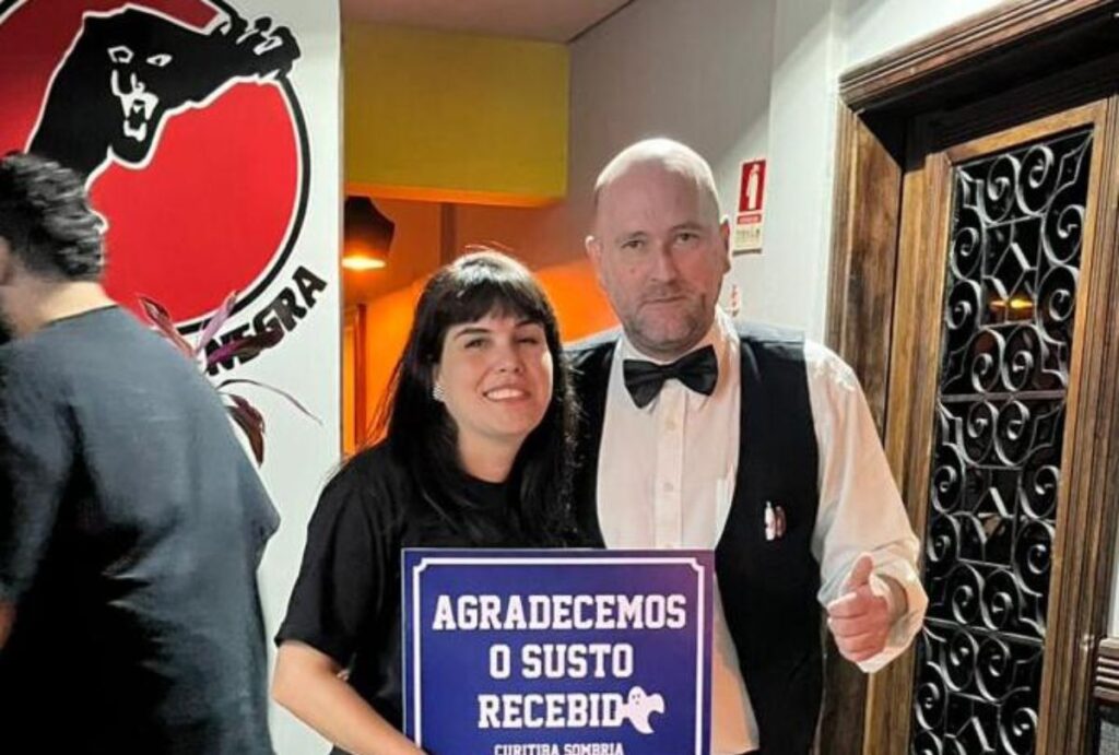 Duas pessoas segurando uma placa.