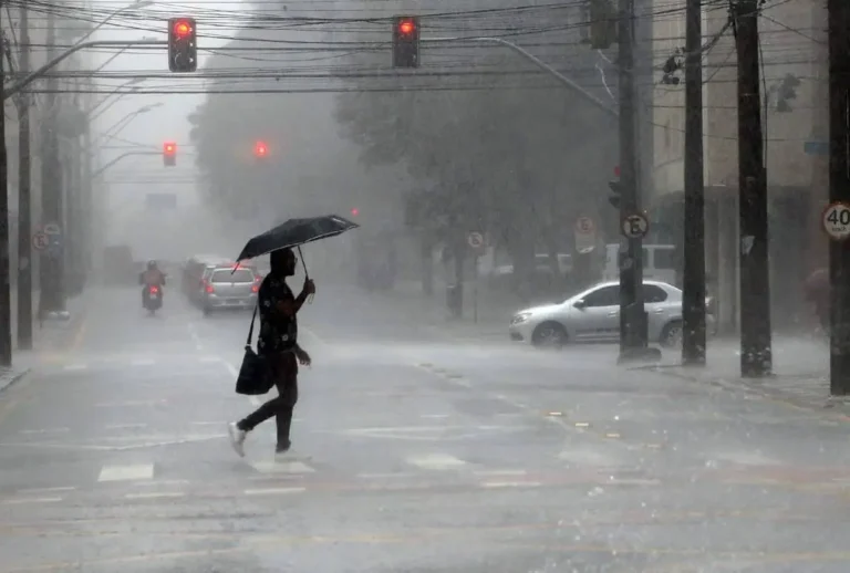 Pessoa atravessando a rua com guarda-chuva