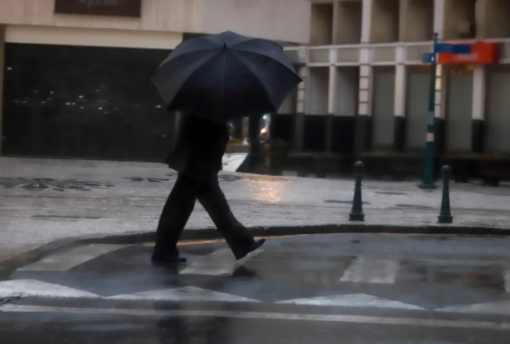 Homem caminhando na chuva
