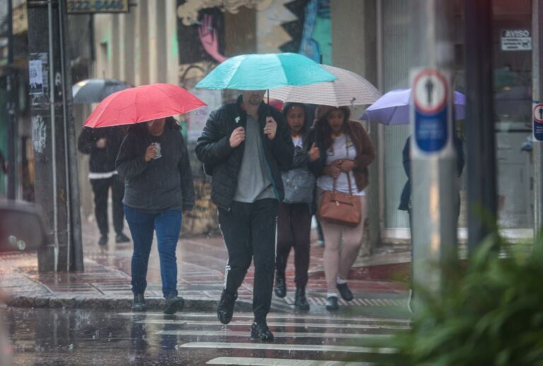 Pessoas com guarda-chuva andando em Curitiba