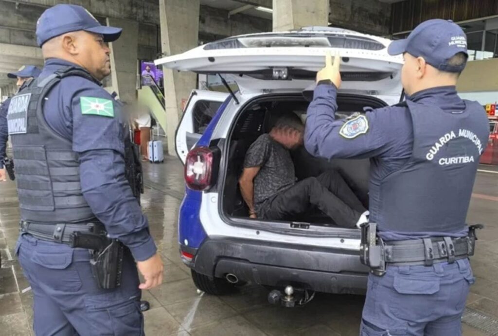 Agentes da guarda munipal prendendo homem foragido.