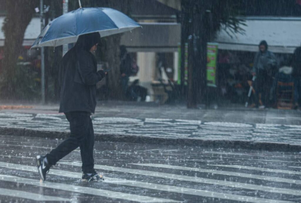 Pessoa atravessando a rua na chuva