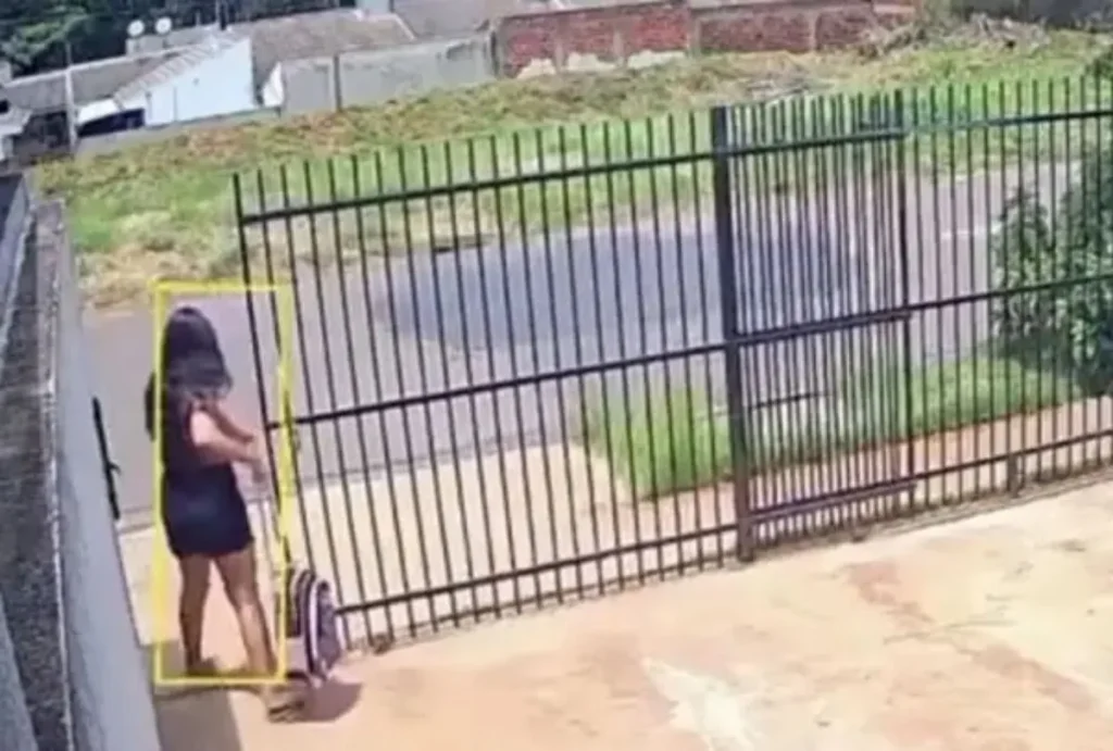 Mulher em portão com mochila.