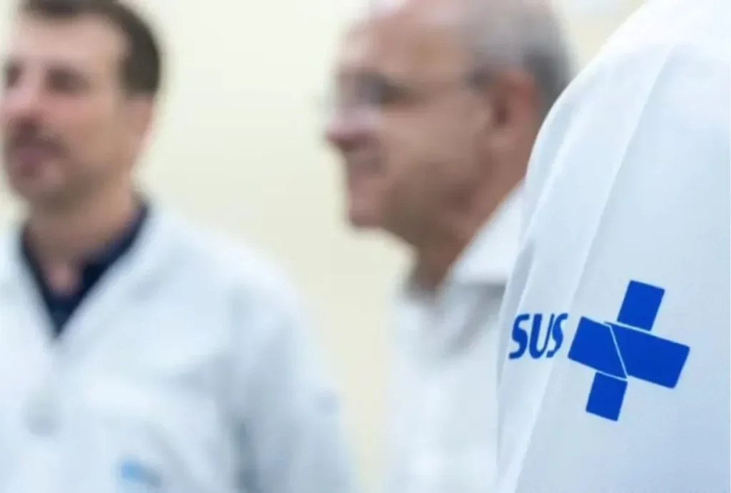 Médicos reunídos com símbolo do SUS em destaque.
