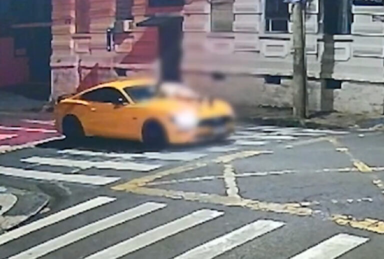 Print de câmera de segurança com mulher agarrada no capô de Mustang amarelo