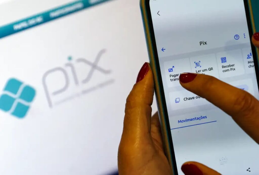 Pessoa segurando o celular para fazer um Pix