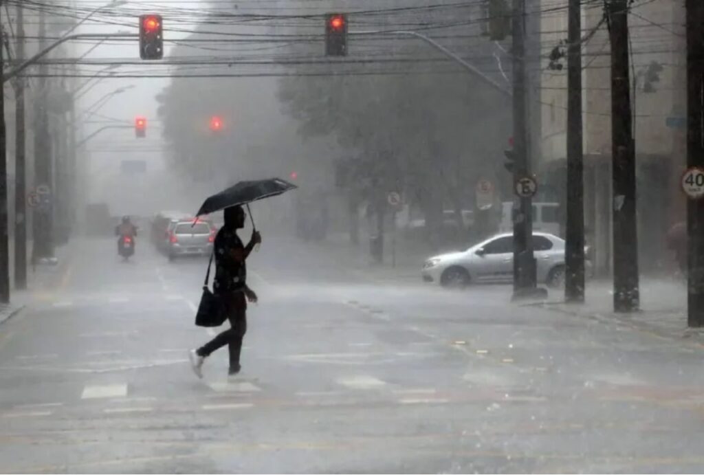 Pessoa atravessando a rua com guarda-chuva